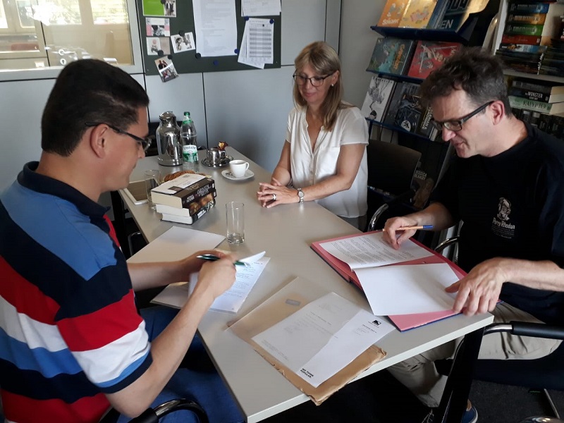 Rodrigo de Lélis (esquerda), Sabine Kropp e Klaus N. Frick (direita) durante a assinatura do contrato para os próximos lançamentos da SSPG.